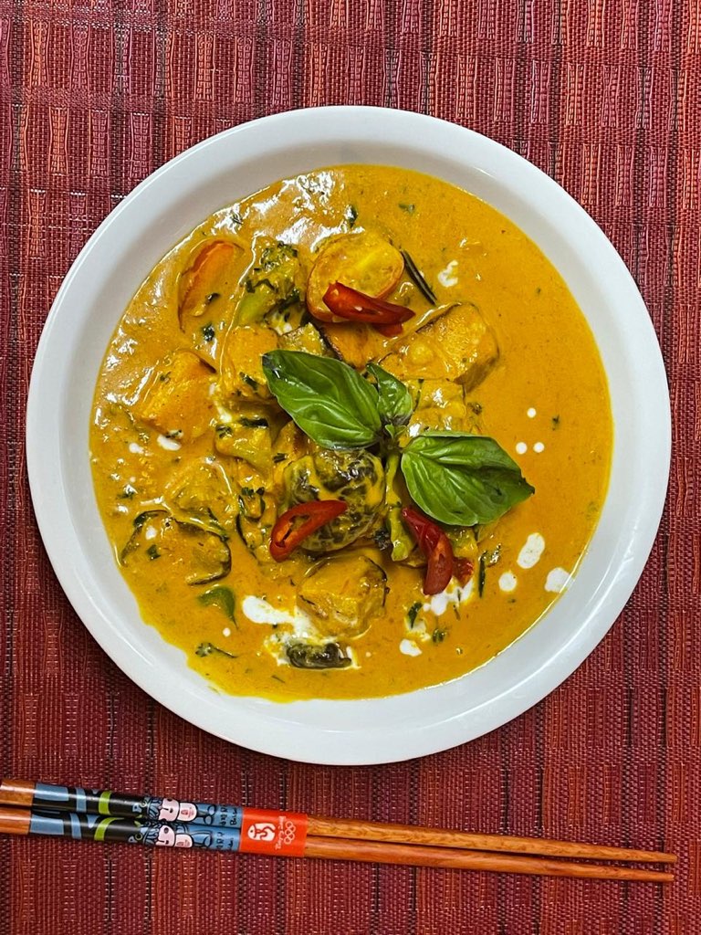 Chef preparing signature golden curry with fresh ingredients